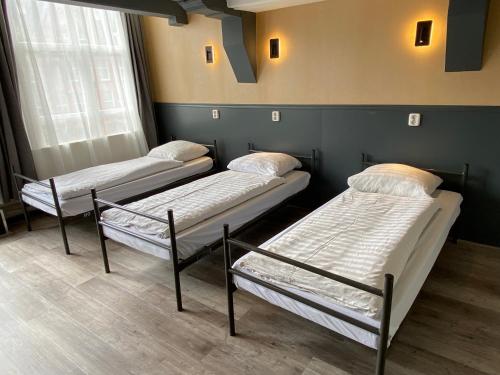 阿姆斯特丹Xplore Hostel Amsterdam的三个床在一间房间里排成一排