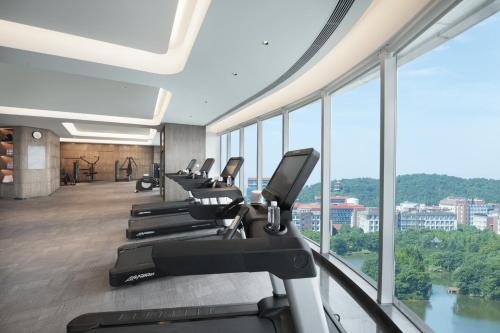 武汉武汉光谷皇冠假日酒店的一间健身房,里面设有一排跑步机和椭圆机