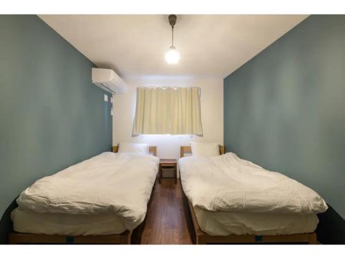 东京rakuna Inn Dou-sasazuka - Vacation STAY 47231v的带窗户的客房内设有两张单人床。
