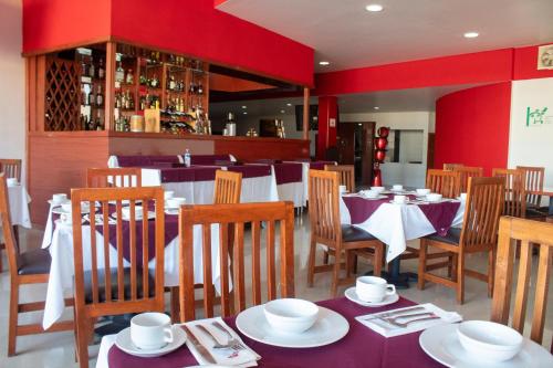 托卢卡Hotel Palass的一间带桌椅和红色墙壁的餐厅