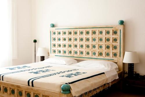 卡洛福泰品皮娜别墅酒店的一间卧室配有一张大床和木制床头板