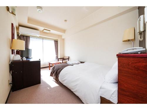 东京Sky Heart Hotel Koiwa - Vacation STAY 49100v的卧室配有白色的床和电话