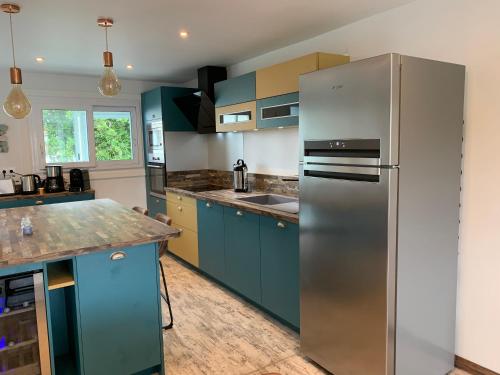 波尔尼谢CapriBeach的厨房配有蓝色橱柜和不锈钢冰箱