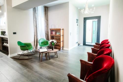 科莫In Centro Luxury Rooms的一间设有绿色椅子和桌子的等候室