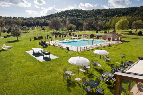 圣吉米纳诺Hotel & Restaurant Casolare Le Terre Rosse的享有带遮阳伞的游泳池的顶部景致