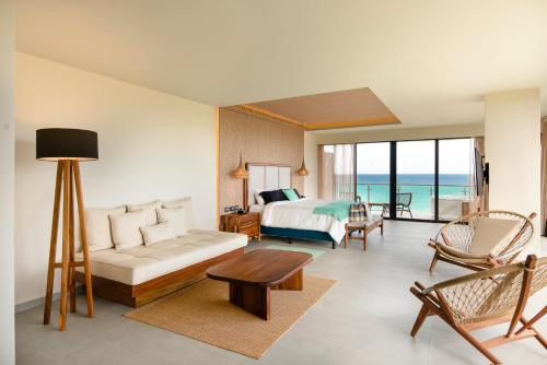 普拉亚卡门Mvngata Beach Hotel的一间带一张床的客厅和一间海洋卧室