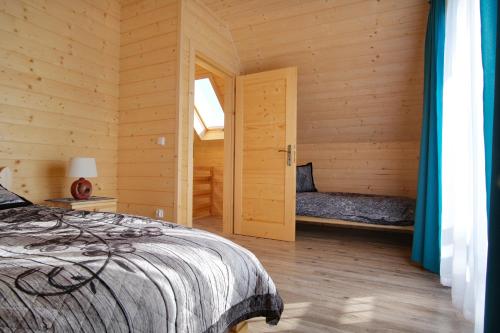 斯扎法拉瑞Domek na farmie的小木屋内一间卧室,配有一张床