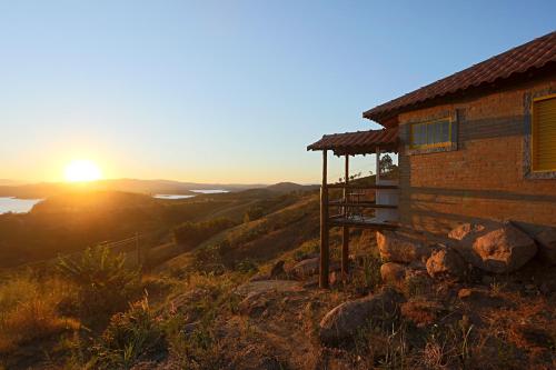 卡孔德Pousada do Xerife的山丘上的房子,背景是日落