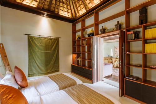 金巴兰Pronoia Beach Resort的一间卧室设有一张床和一个大窗户