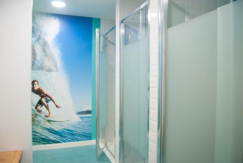 马略卡岛帕尔马帕尔马阿尔贝古约维尼尔旅舍的浴室在海上的冲浪板上贴有一名妇女的海报