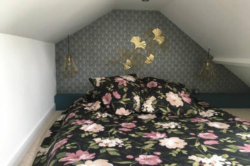 BraineLa petite Brainoise - Gîte avec salle jacuzzi 120 jets的一间卧室配有一张带花卉床罩的床