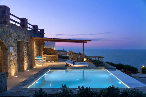 斯泰里达Naxos Rock Villas的夜间带游泳池的别墅