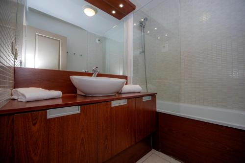 曼德琉-拉纳普勒Goélia Mandelieu Riviera Resort的一间带水槽和淋浴的浴室