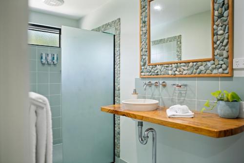 埃尔利海滩Airlie Guest House的一间带水槽和镜子的浴室