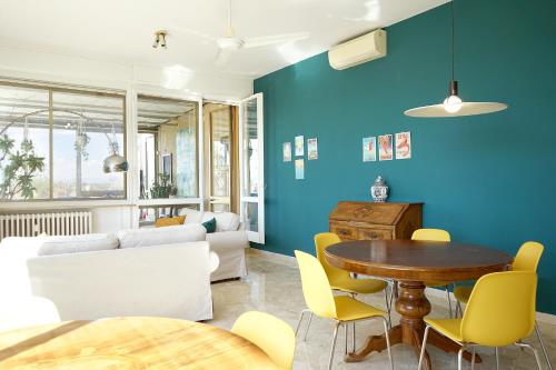 里米尼Family Dream Penthouse的客厅配有桌子和黄色椅子