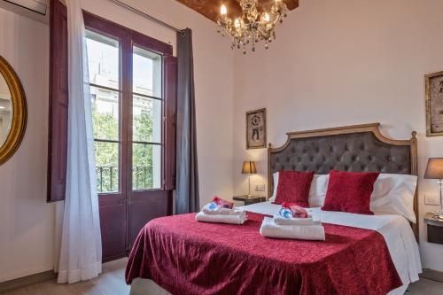 巴塞罗那阿尔卡姆图书酒店的一间卧室配有一张带红色毯子的大床
