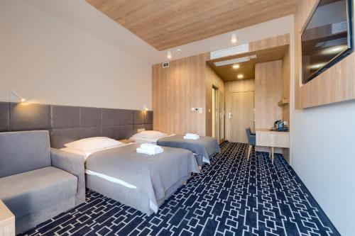 弗罗茨瓦夫维纳酒店的酒店客房,设有两张床和一张沙发