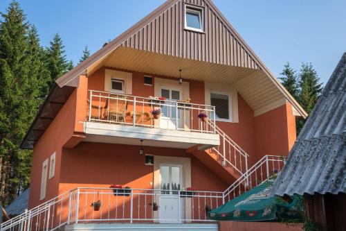 扎布利亚克Apartments Dedeic的一座橙色的房子,设有阳台和树木