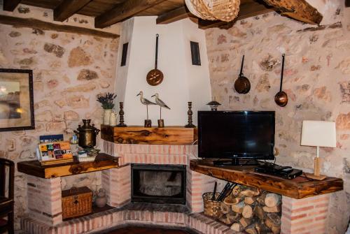 CaballarLa Fuente del Poval的一间带电视和壁炉的客厅