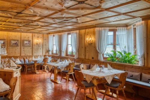 伊施格尔Gasthof Alt Paznaun的餐厅拥有木墙和桌子,设有窗户