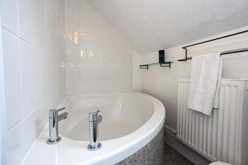MoortownCosy 2 Bed Apartment - Close to Leeds Centre的白色的浴室设有浴缸和水槽。