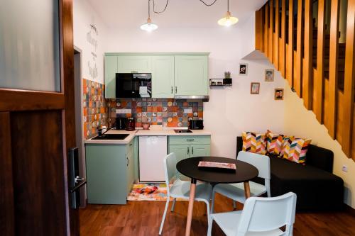锡比乌Galeria Grafit Apartments的一间带小桌子和沙发的小厨房