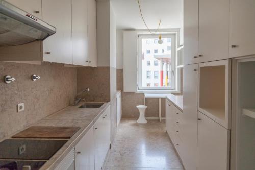 里斯本Classy 2BDR Apartment in Downtown by LovelyStay的厨房配有白色橱柜和窗户。