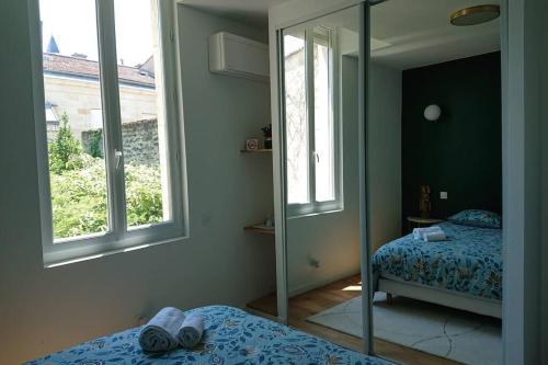 波尔多T2 calme et design quartier Chartrons à Bordeaux的一间带镜子、一张床和镜子的卧室