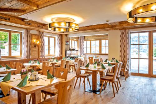 圣沃尔夫冈Landhaus Leopoldhof的餐厅设有木桌、椅子和窗户。