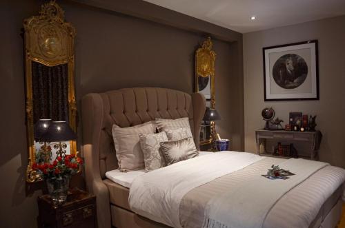 DeerlijkLa Maison Des Papillons的一间卧室配有一张金色床架的大床