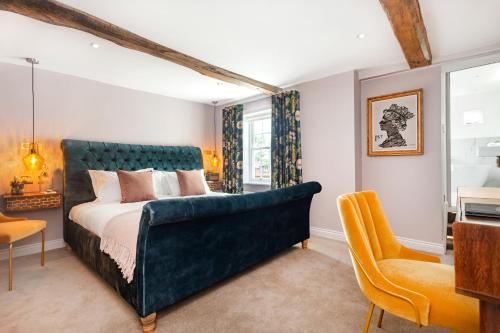 霍克赫斯特女王之旅馆的一间卧室配有一张大床和蓝色床头板