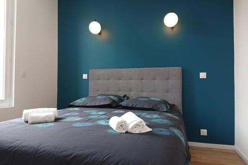 波尔多appartement 4 pers quartier Chartrons à Bordeaux的蓝色卧室,配有带毛巾的床