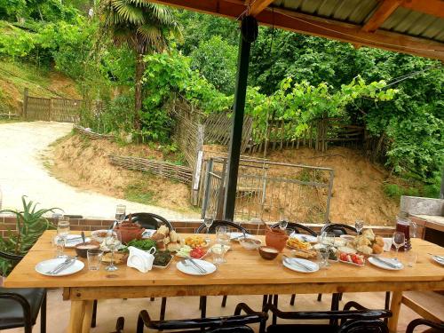 Khelvach'auriAgro Guest House Tsiskari in Machakhela的一张木桌,上面放着食物和酒杯