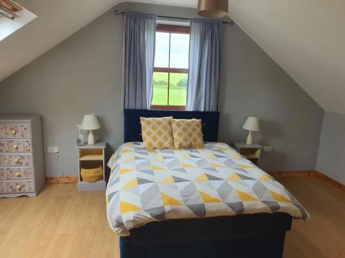 特拉利Murphys Irish Farmhouse的一间卧室配有一张蓝色和黄色的被子