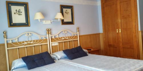 哈兰迪雅·德·拉·维尔甘特旅馆的一间卧室配有一张带两个蓝色枕头的床