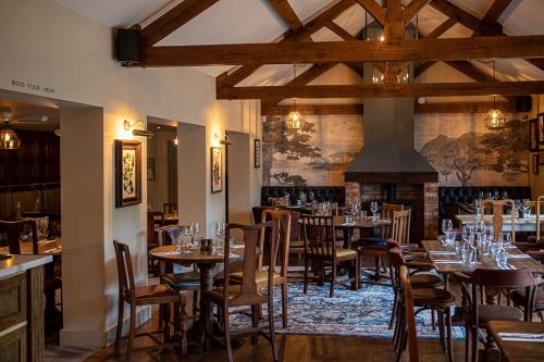 布罗肯赫斯特The Filly Inn的一间带桌椅和壁炉的餐厅