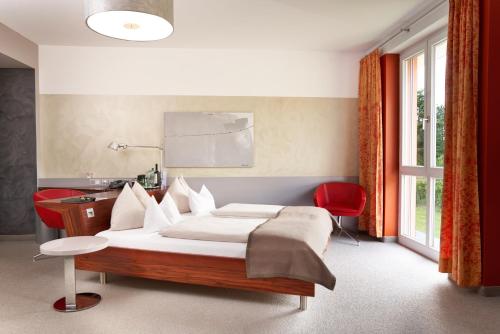 韦尔斯麦克斯哈德酒店的一间卧室配有一张床和一张红色椅子