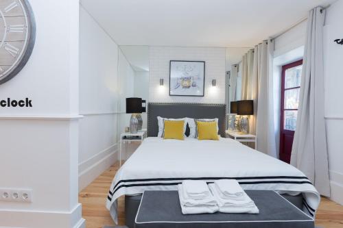波尔图Loureiro Villas的白色卧室配有一张带黄色枕头的大床