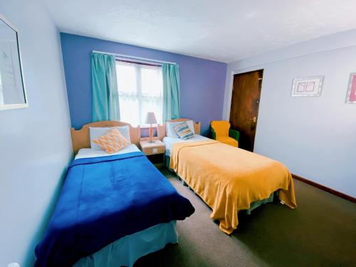 SawtryRedwings Lodge Sawtry Huntingdon的蓝色的客房设有两张床和窗户。