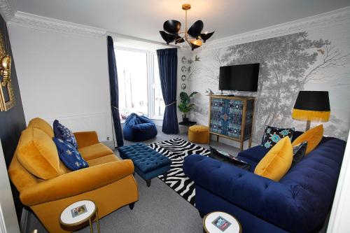 马伯斯Sea Watch Seafront Holiday House的客厅配有蓝色椅子和蓝色沙发