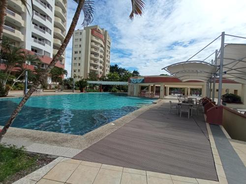 通苏帕Departamento 4 habitaciones 12 personas vista al mar 8vo piso Playa Almendro的一座带桌椅的游泳池以及大楼