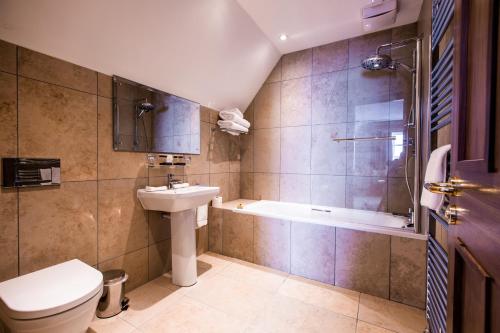 拉恩巴里加里城堡酒店的一间带水槽、浴缸和卫生间的浴室