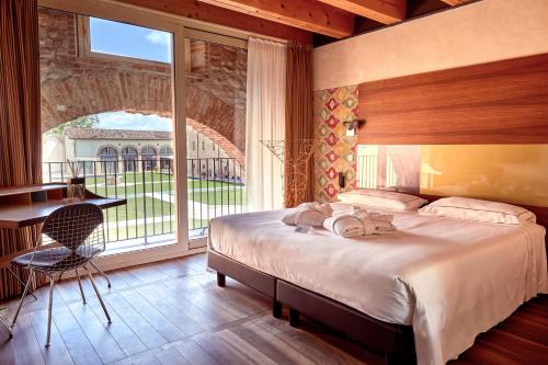 多索博诺韦罗内西拉托雷酒店的一间卧室配有一张床、一张书桌和一个窗户。