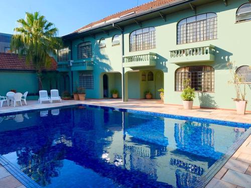 托莱多Vila Verde Hotel的一座房子前面设有游泳池