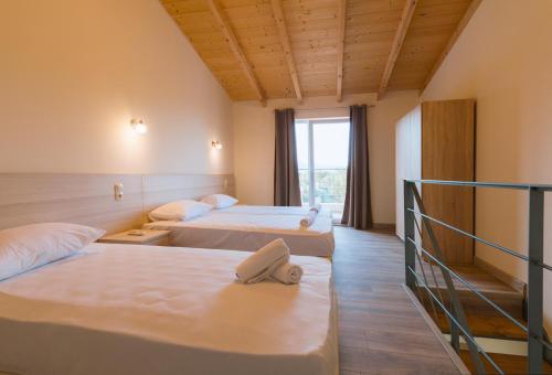 古维亚Luca Mare的酒店客房设有两张床和窗户。