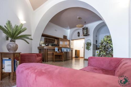 贝卢诺艾尔伯格凯佩罗伊卡多雷酒店的客厅配有粉红色的沙发和桌子