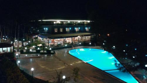 帕莫卡莱Pamukkale Whiteheaven Suite Hotel的一座游泳池,在晚上在建筑物前