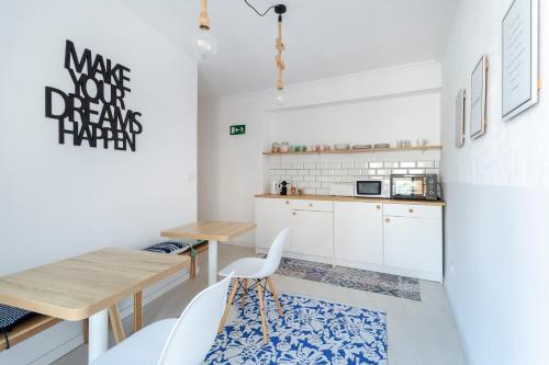 阿利坎特Casa M&J GuestHouse的厨房配有白色橱柜和木桌