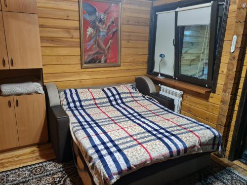 基辅Деревянный 2-х комнатный домик的一间卧室设有一张床和一个窗口
