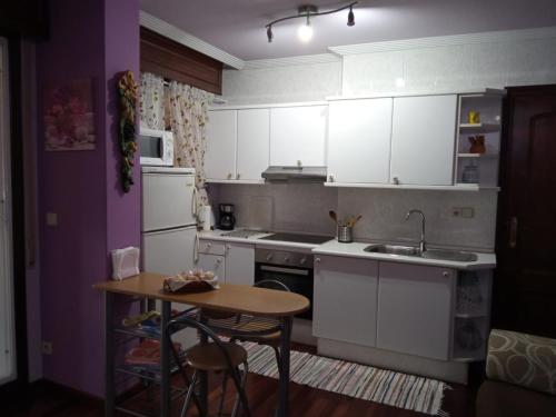 维戈Apartamento Duplex Vigo的厨房配有白色橱柜、桌子和水槽。